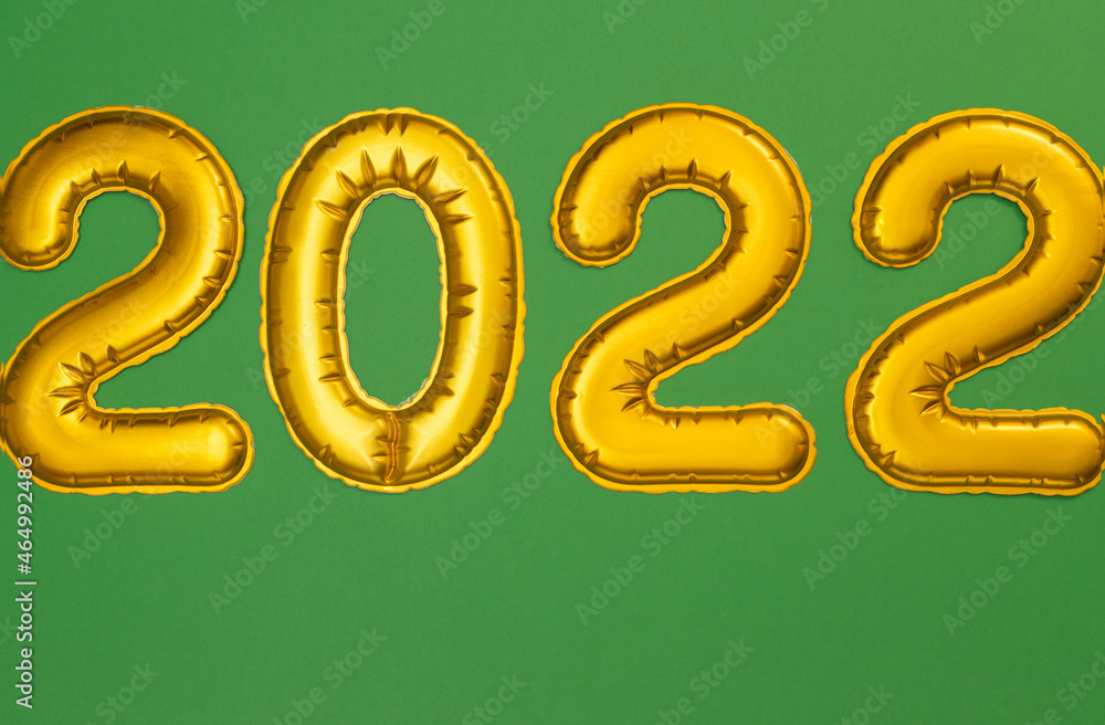 Happy New Year 2022. Golden numbers ion a green background close-up. the concept of a postcard with a top view. Happy New Year 2022. Golden numbers ion a green background close-up. the concept of a postcard with a top view.