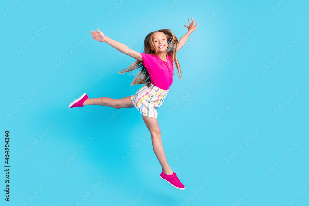 Full body photo of happy cheerful joyful small girl hands wings fly isolated on blue color background Full body photo of happy cheerful joyful small girl hands wings fly isolated on blue color background