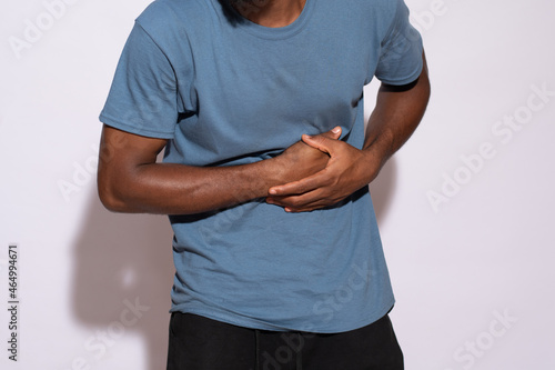 ill black man holding his stomach in discomfort
