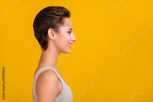 Profile photo of cheerful nice pretty lady look empty space shiny smile wear grey top isolated yellow color background