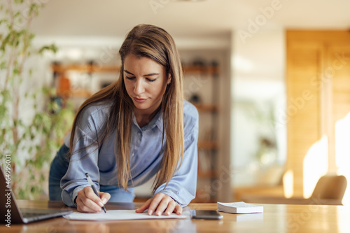 Adult woman, writing down everything she hears.