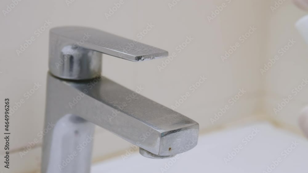 Hand hands wearing white gloves use sanitizer clean tap before use at public toilet under the outbreak covid 19 Hand hands wearing white gloves use sanitizer clean tap before use at public toilet under the outbreak covid 19