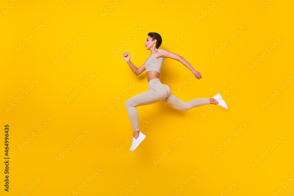 Full length body size profile side view of pretty girl jumping running weight loss isolated over bright yellow color background