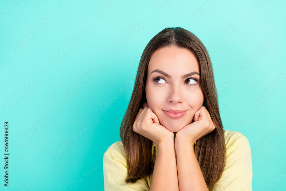 Photo of happy young dreamy woman look empty space hands face good mood isolated on teal color background Photo of happy young dreamy woman look empty space hands face good mood isolated on teal color background