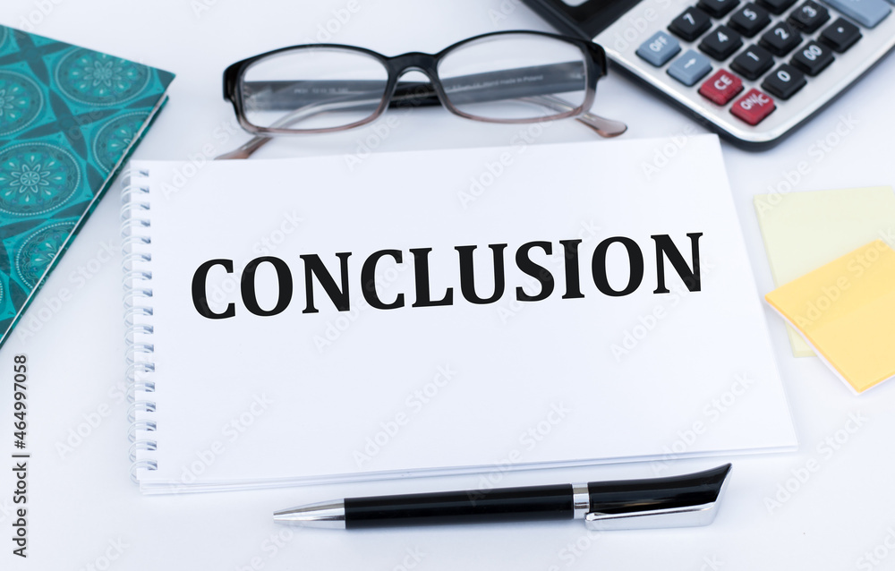 Conclusion text on a notepad on an office table near a pen, calculator, glasses, notepad Conclusion text on a notepad on an office table near a pen, calculator, glasses, notepad
