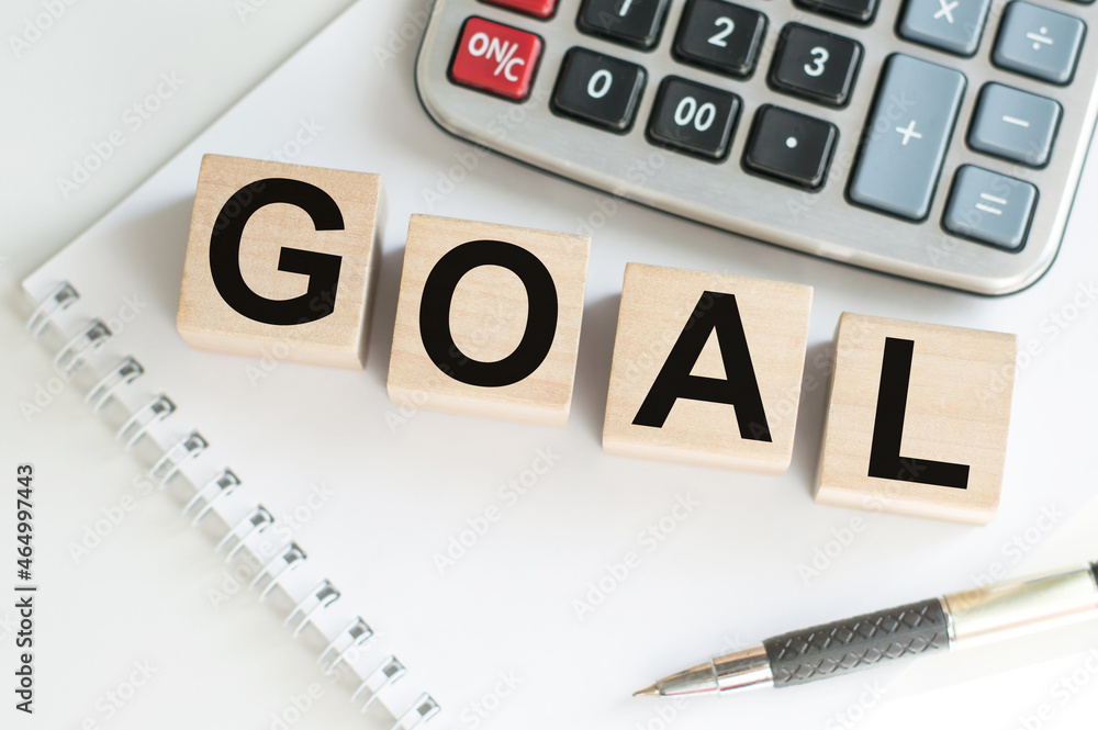 The cubes make up the world GOALS, wooden cubes are on a white notebook on the table. Business concept. The cubes make up the world GOALS, wooden cubes are on a white notebook on the table. Business concept.