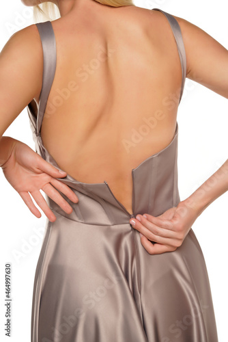 Obraz na plátne Back view of a young lady unzip her evening dress
