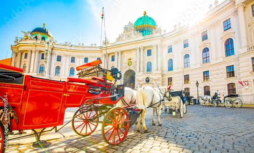 Foto Hofburg palace and horse carriage on sunny Vienna street, Austria