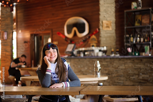 beautiful girl resting and talking on the phone in a cafe ski resort
