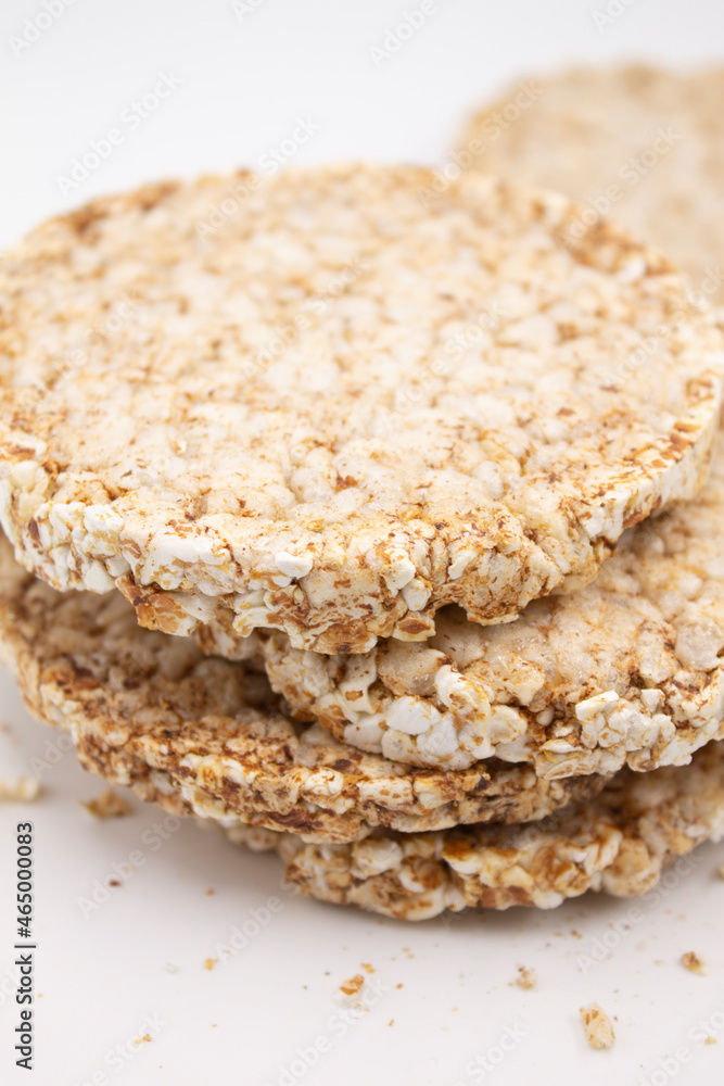 Round bread healthy food from bran, lying on top of each other on a white background, next to crumbs Round bread healthy food from bran, lying on top of each other on a white background, next to crumbs
