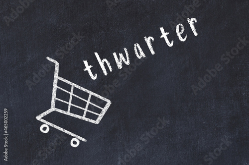 Chalk drawing of shopping cart and word thwarter on black chalboard. Concept of globalization and mass consuming photo