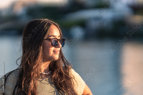Portrait of a young caucasian woman with sunglasses facing the sunset outdoors © Samuel Perales