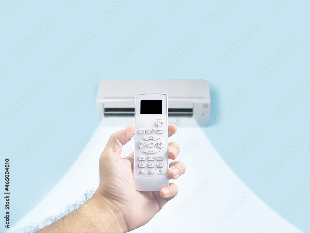Human hand holding air conditioner remote control for regulate temperature, on the remote, there is a black blank display Human hand holding air conditioner remote control for regulate temperature, on the remote, there is a black blank display