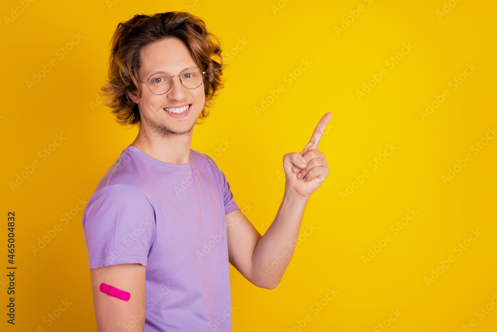 Vaccinated man direct forefinger empty space ad banner on yellow background