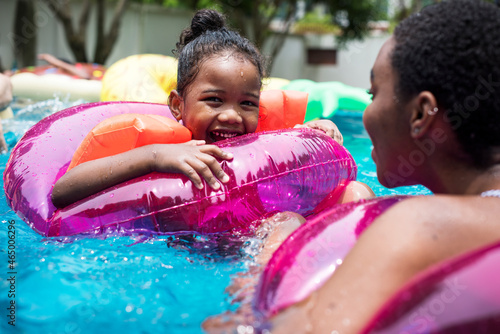 Принти на полотні Closeup of black mother and daughter enjoying the pool with inflatable tubes