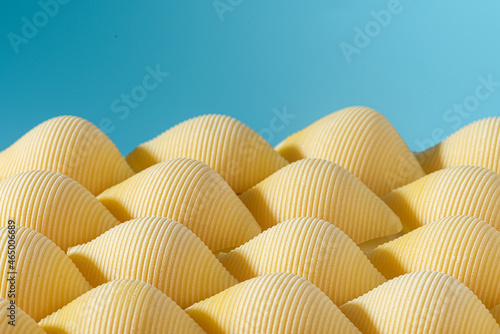 Pasta conchiglioni or conchiglie pattern with blue background. Abstract creative food concept