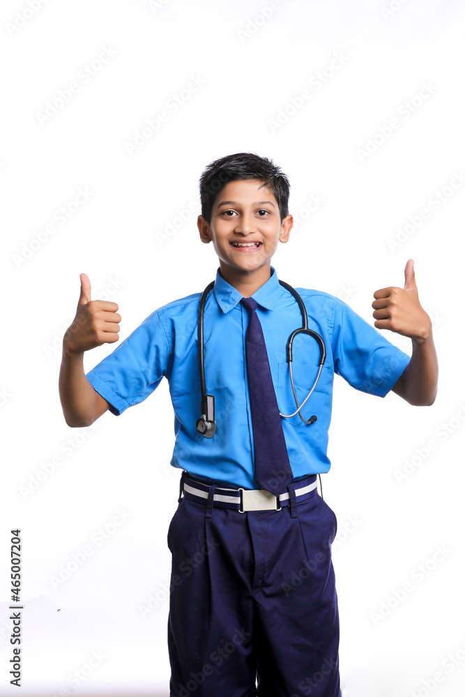 Indian little boy in school uniform playing with stethoscope isolated on white background Indian little boy in school uniform playing with stethoscope isolated on white background
