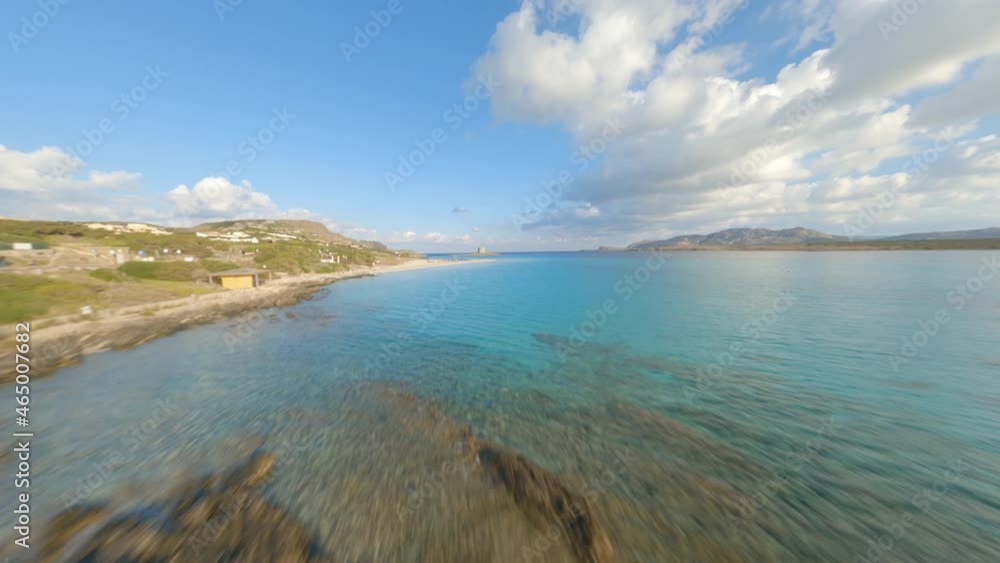 FPV video, view from above, flying at high speed over a turquoise water with a beautiful white sand beach La Pelosa Beach, Stintino,. Sardinia, Italy. FPV video, view from above, flying at high speed over a turquoise water with a beautiful white sand beach La Pelosa Beach, Stintino,. Sardinia, Italy.