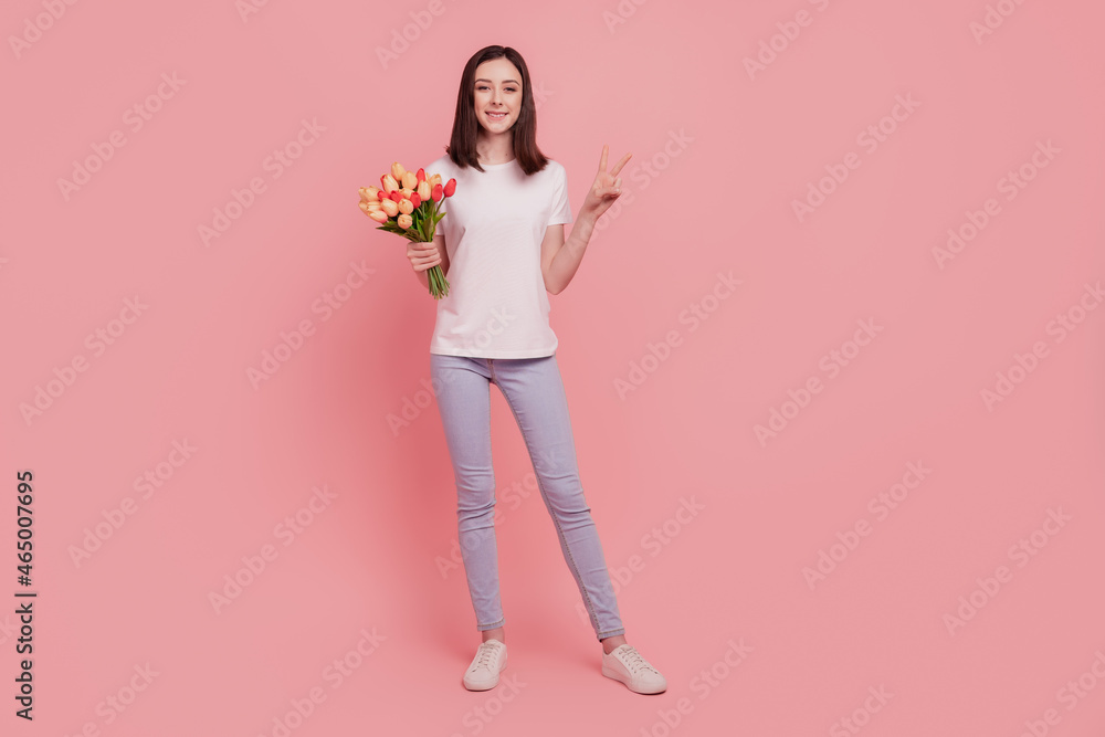 Photo of pretty cute girlfriend hold bouquet tulips show v-sign isolated pink color background Photo of pretty cute girlfriend hold bouquet tulips show v-sign isolated pink color background