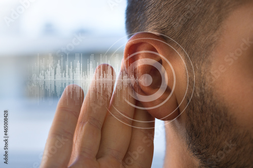 Young man with hearing problems or hearing loss. Hearing test concept.