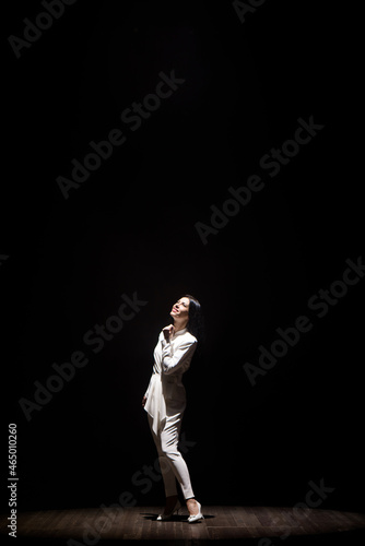 Woman model on stage demonstrates a trouser white suit