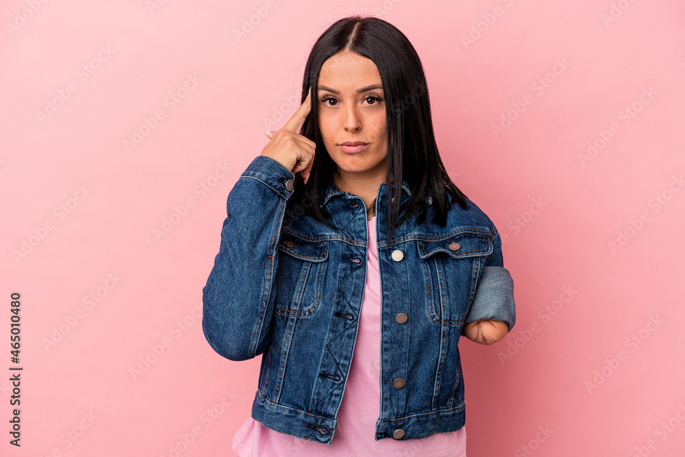 Young caucasian woman with one arm isolated on pink background pointing temple with finger, thinking, focused on a task. Young caucasian woman with one arm isolated on pink background pointing temple with finger, thinking, focused on a task.