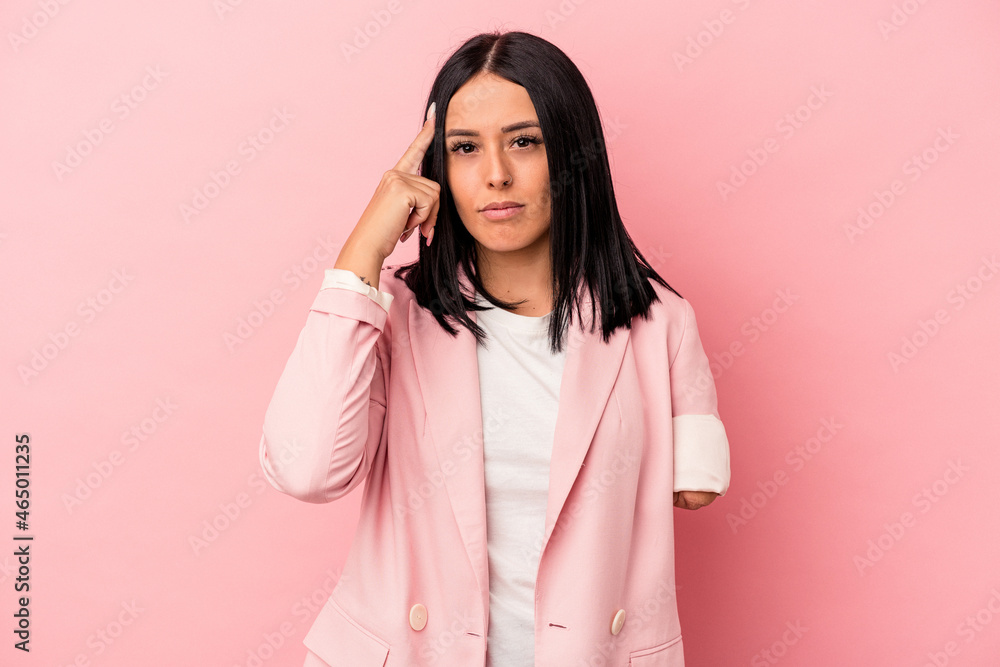 Young caucasian woman with one arm isolated on pink background pointing temple with finger, thinking, focused on a task. Young caucasian woman with one arm isolated on pink background pointing temple with finger, thinking, focused on a task.