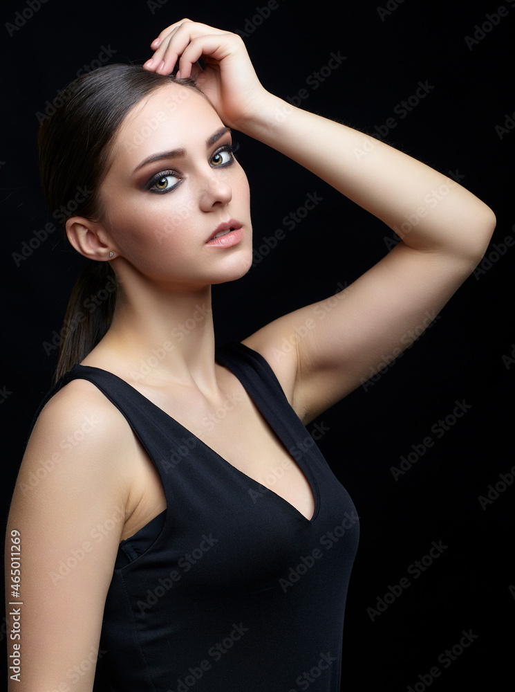 Beauty portrait of young woman. Brunette girl with evening female makeup and black dress Beauty portrait of young woman. Brunette girl with evening female makeup and black dress