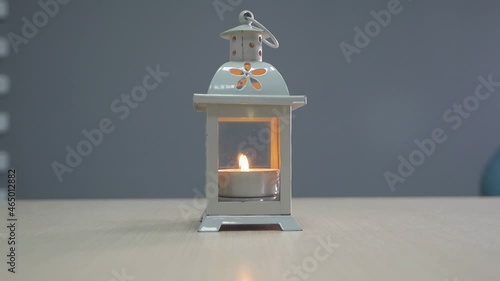 candle burns in a white candlestick
