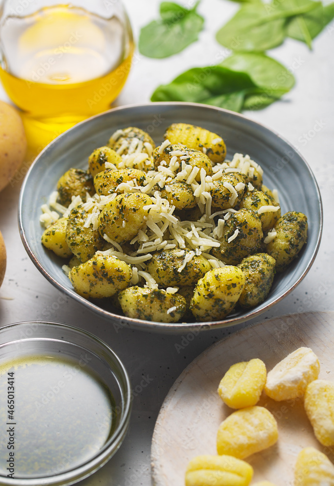 Traditional gnocchi with pesto sauce in gray bowl. It usually prepared with potato and dough Traditional gnocchi with pesto sauce in gray bowl. It usually prepared with potato and dough