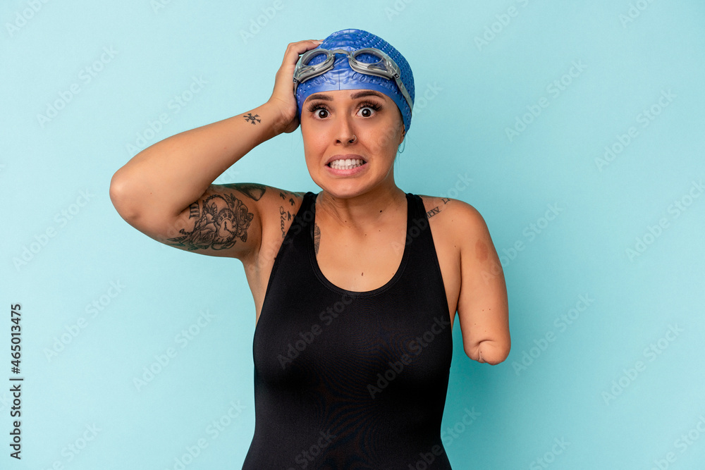 Young swimmer caucasian woman with one arm isolated on blue background being shocked, she has remembered important meeting. Young swimmer caucasian woman with one arm isolated on blue background being shocked, she has remembered important meeting.