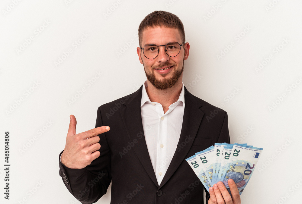 Young business caucasian man holding banknotes isolated on white background person pointing by hand to a shirt copy space, proud and confident Young business caucasian man holding banknotes isolated on white background person pointing by hand to a shirt copy space, proud and confident