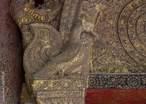 Beautiful ancient gilded wood and stucco carving of mythical swan bird aka hong or hangsa at the entrance of historical viharn Lai Kham, Wat Phra Singh buddhist temple, Chiang Mai, Thailand