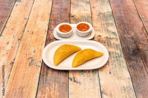 Colombian corn empanadas with dipping sauces on white porcelain plates