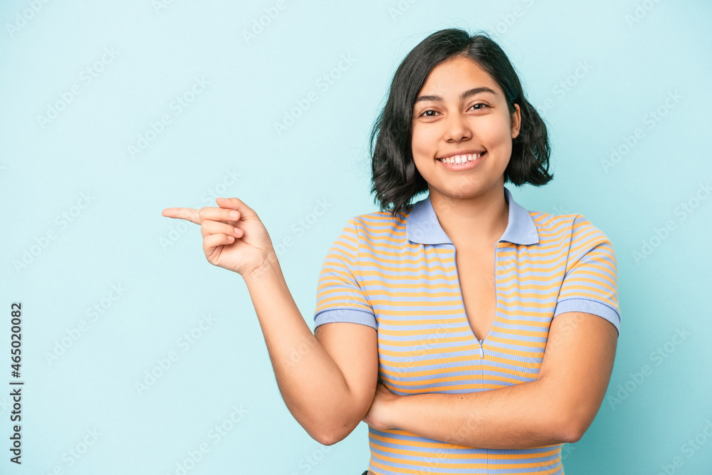 Young latin woman isolated on blue background smiling cheerfully pointing with forefinger away. Young latin woman isolated on blue background smiling cheerfully pointing with forefinger away.