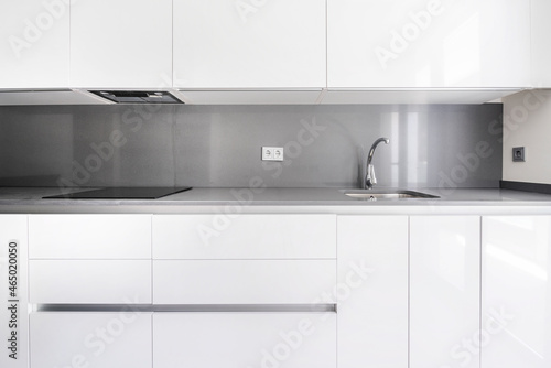 Front image of a modern kitchen furnished in white and gray tones in a vacation rental unit