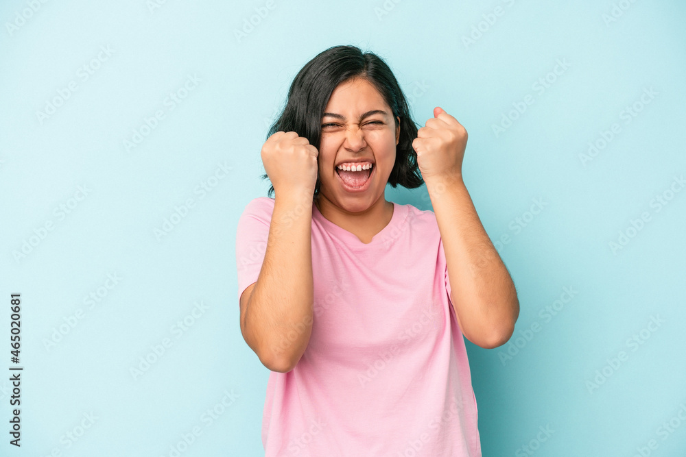 Young latin woman isolated on blue background cheering carefree and excited. Victory concept. Young latin woman isolated on blue background cheering carefree and excited. Victory concept.