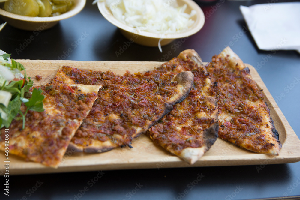 Lahmacun, a round, thin piece of dough topped with minced meat (most commonly beef or lamb), minced vegetables and herbs Lahmacun, a round, thin piece of dough topped with minced meat (most commonly beef or lamb), minced vegetables and herbs