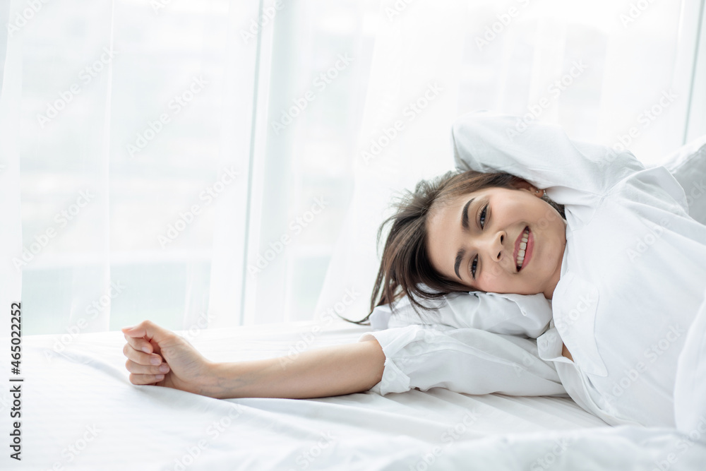 Asian woman Beautiful young smiling woman sitting and sleeping in white bed and stretching in the morning at bedroom after waking up in her bed fully rested Asian woman Beautiful young smiling woman sitting and sleeping in white bed and stretching in the morning at bedroom after waking up in her bed fully rested
