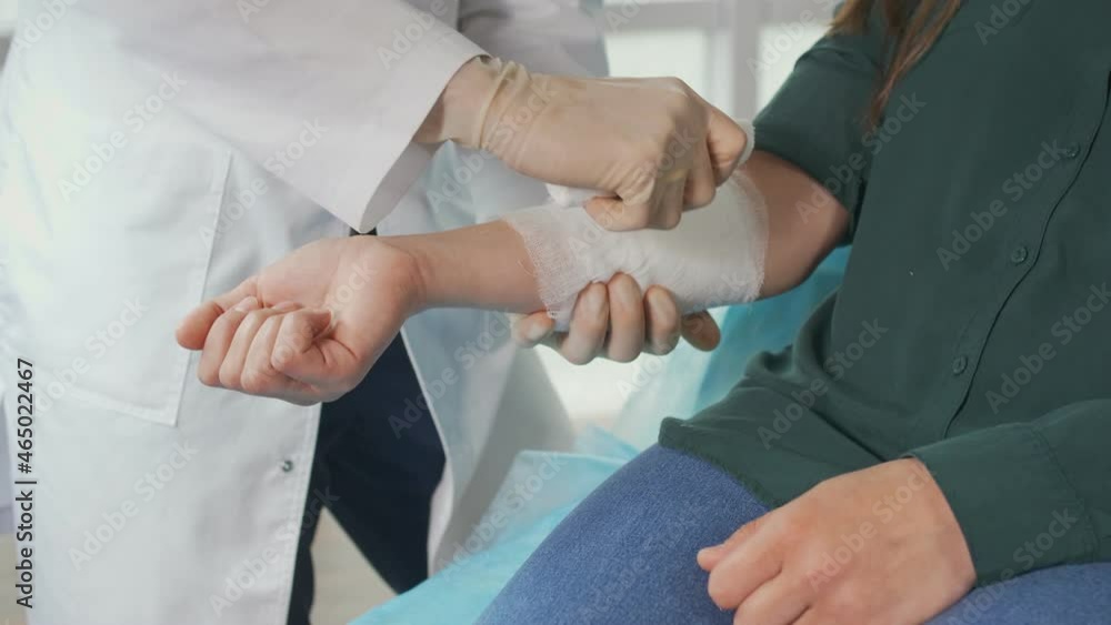 A Physical Therapist Applies a Bandage to a Patient'S Injured Arm in the Clinic'S Office. Medical Procedures in the Clinic. Health Insurance Medical Service Concept. A Physical Therapist Applies a Bandage to a Patient'S Injured Arm in the Clinic'S Office. Medical Procedures in the Clinic. Health Insurance Medical Service Concept.