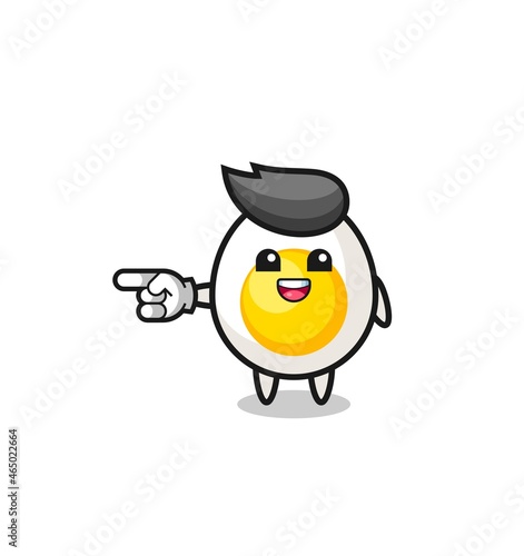 boiled egg cartoon with pointing left gesture © heriyusuf