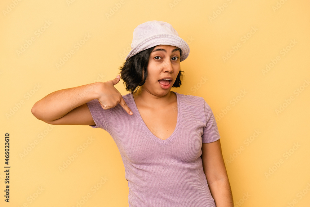 Young latin woman isolated on yellow background person pointing by hand to a shirt copy space, proud and confident Young latin woman isolated on yellow background person pointing by hand to a shirt copy space, proud and confident