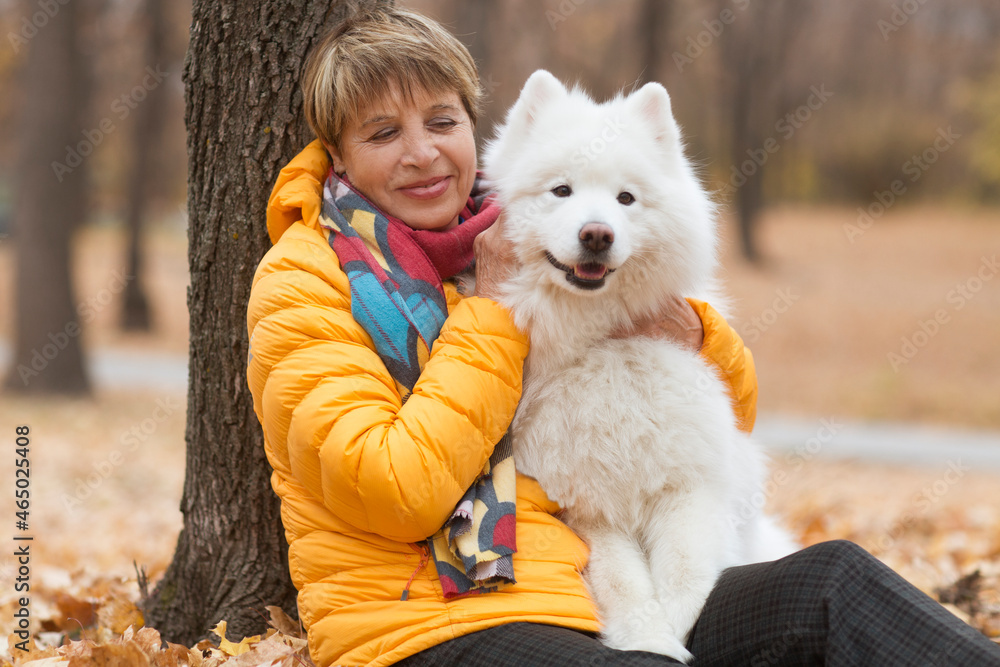 senior woman walk with a dog in the autumn park
senior woman walk with a dog in the autumn park