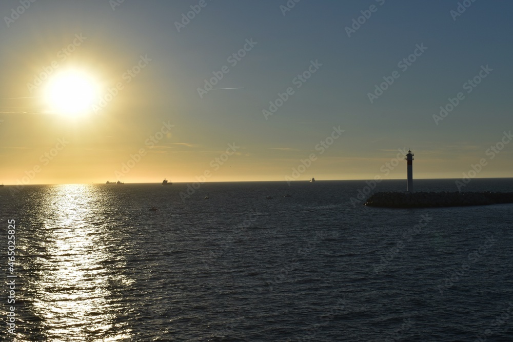 
A lighthouse and some ships in the sea