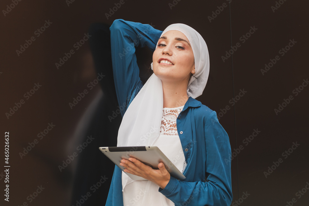 Beautiful muslim girl using digital tablet for communication with friend outdoor Beautiful muslim girl using digital tablet for communication with friend outdoor