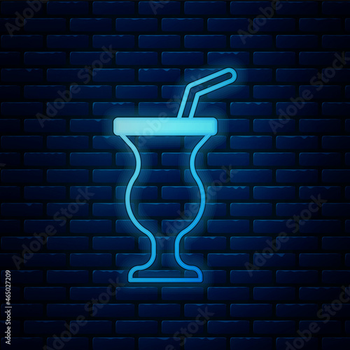 Glowing neon Milkshake icon isolated on brick wall background. Plastic cup with lid and straw. Vector