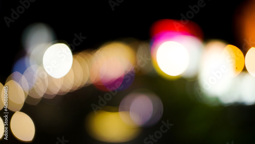 the vehicle's light in an urban night. blurry shot of the night lamp in the park. pretty scene of the cityscape.