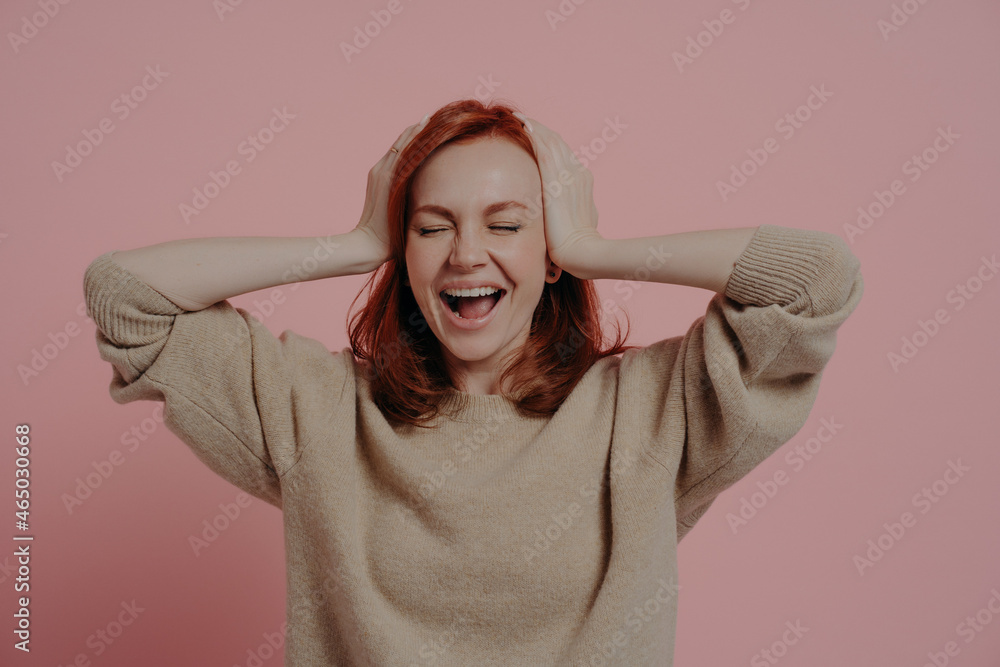 Excited caucasian red-haired woman reacting positively on good news isolated over pink background Excited caucasian red-haired woman reacting positively on good news isolated over pink background