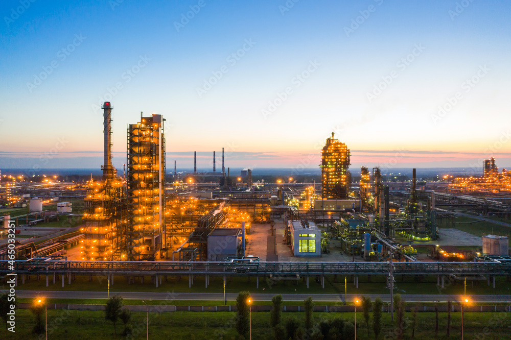 Oil refinery plant industry, Refinery factory. oil storage tank, rectification column and pipeline against the backdrop of sunset in summer, Russia