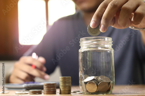 businessman holding coins putting in glass. concept saving money for finance accounting.